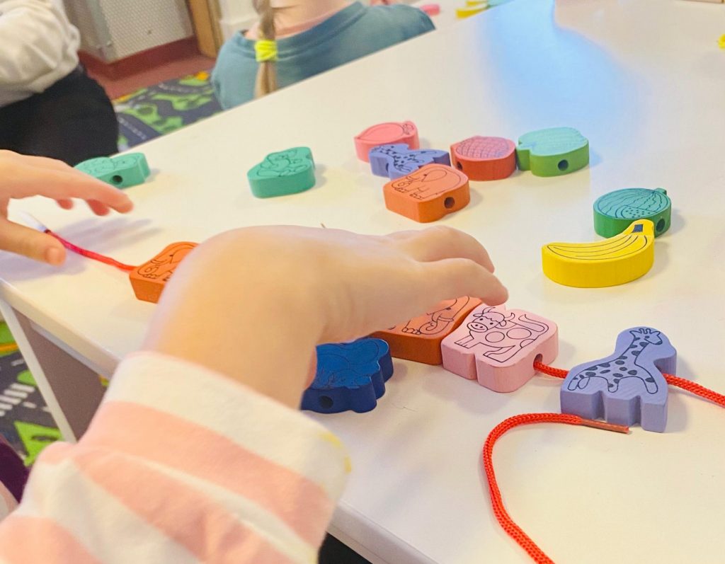 Kind spielt mit farbigen Klötzen